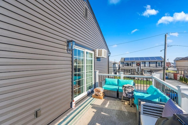 balcony with outdoor lounge area and a wall mounted AC