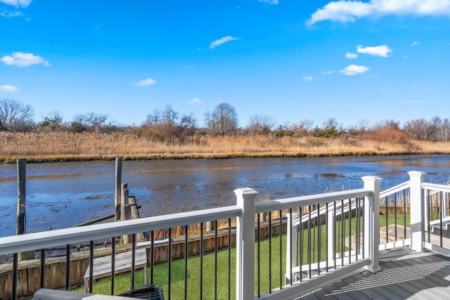 wooden deck featuring a lawn and a water view