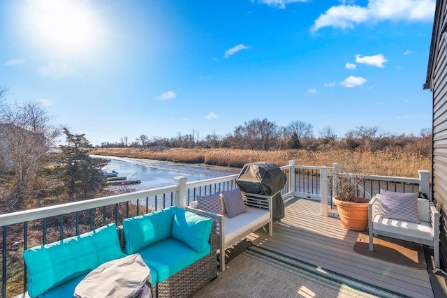 wooden terrace featuring a water view and an outdoor hangout area