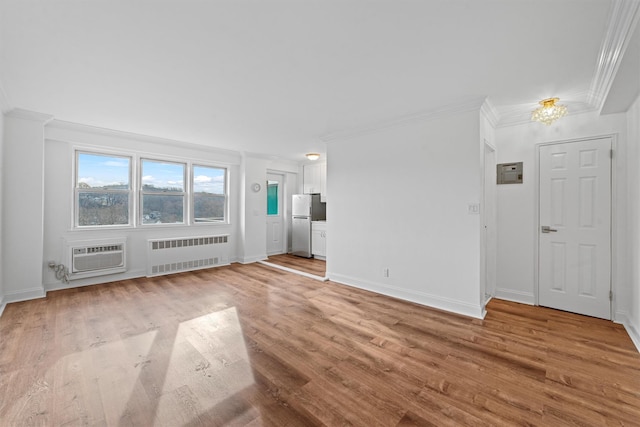 unfurnished living room featuring an AC wall unit, radiator, crown molding, and light hardwood / wood-style flooring