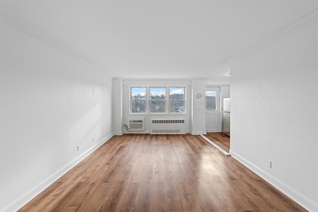 unfurnished living room featuring radiator, crown molding, hardwood / wood-style floors, and a wall mounted AC