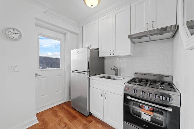 kitchen with white cabinetry, sink, light hardwood / wood-style floors, and appliances with stainless steel finishes