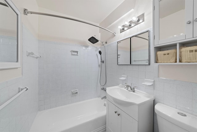 full bathroom featuring vanity, toilet, tile walls, and tiled shower / bath combo