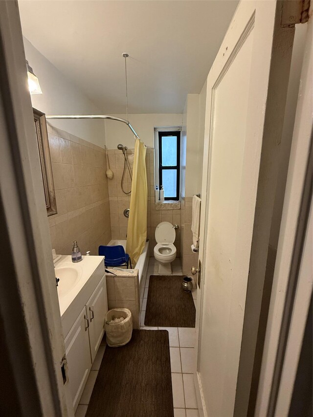 full bathroom with shower / bath combo, tile patterned floors, vanity, tile walls, and toilet