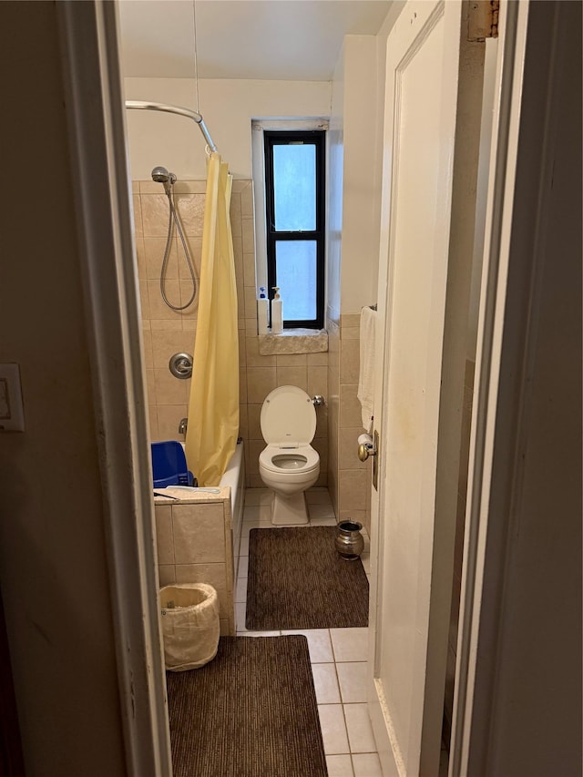 bathroom with toilet, shower / tub combo, tile patterned floors, and tile walls