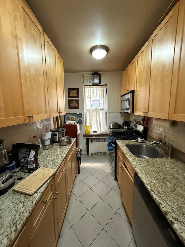 kitchen featuring backsplash, sink, stainless steel appliances, and radiator heating unit