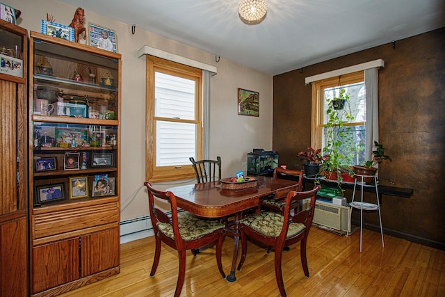 dining room featuring light wood-type flooring and a baseboard heating unit