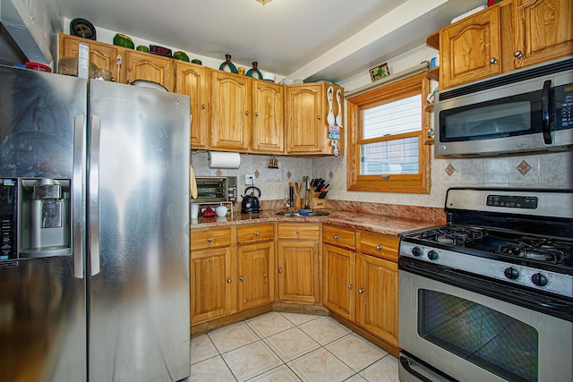 kitchen with tasteful backsplash, light tile patterned floors, and stainless steel appliances