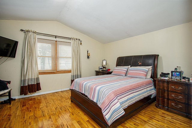 bedroom with lofted ceiling and light hardwood / wood-style floors