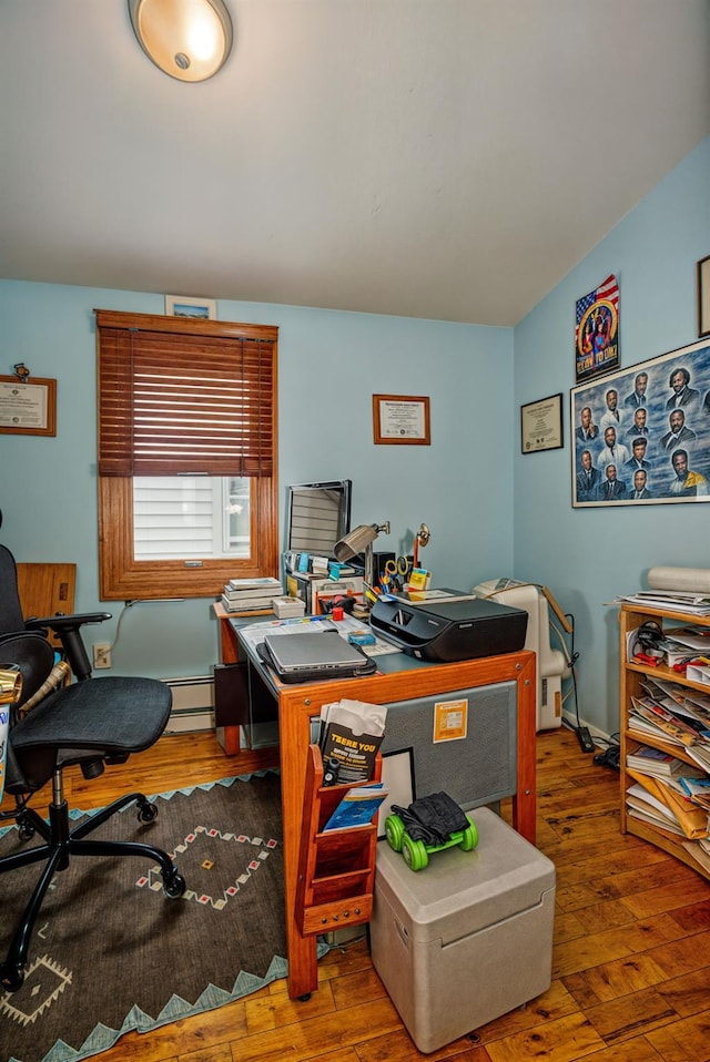 home office featuring a baseboard heating unit and wood-type flooring