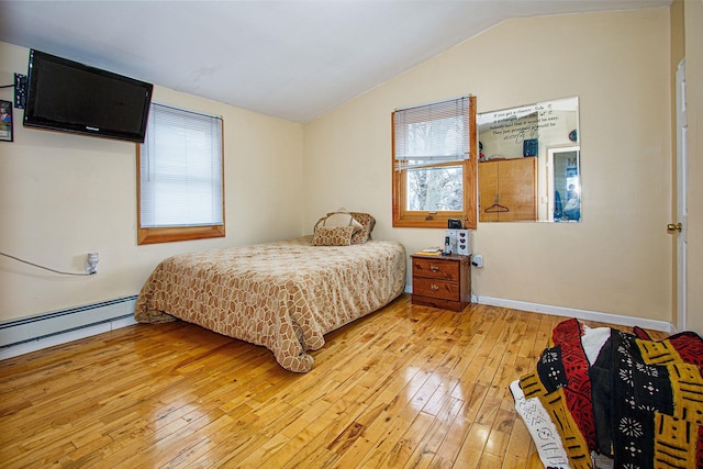 bedroom with a baseboard heating unit, light hardwood / wood-style flooring, and lofted ceiling