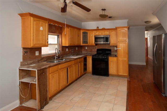 kitchen featuring sink, stainless steel appliances, dark stone countertops, crown molding, and decorative backsplash