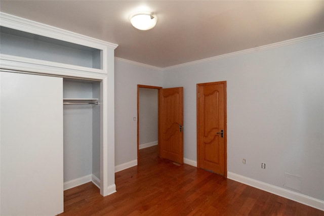 unfurnished bedroom with ornamental molding, a closet, and dark wood-type flooring