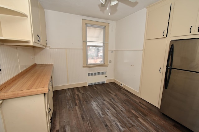 kitchen with stainless steel fridge, dark hardwood / wood-style flooring, radiator, and ceiling fan