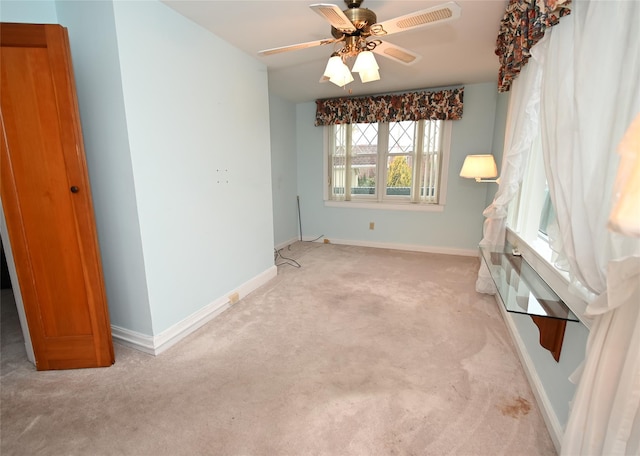 spare room featuring light carpet and ceiling fan