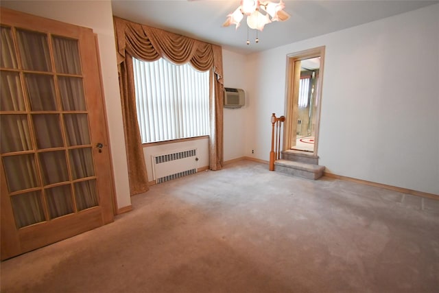 carpeted spare room featuring ceiling fan, radiator heating unit, and a wall mounted air conditioner