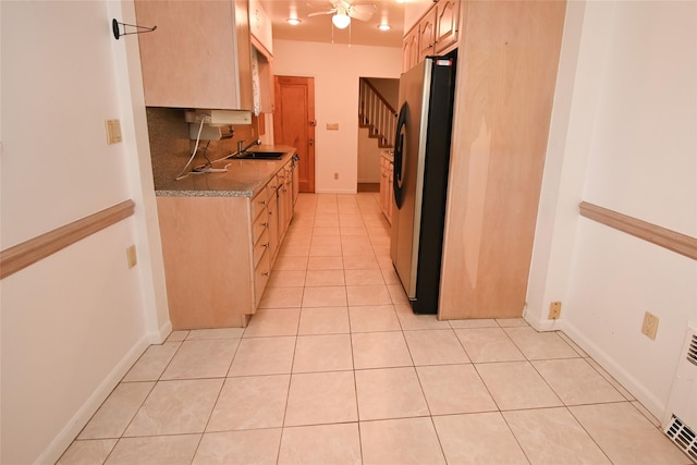 kitchen with decorative backsplash, light brown cabinetry, ceiling fan, stainless steel refrigerator, and light tile patterned flooring