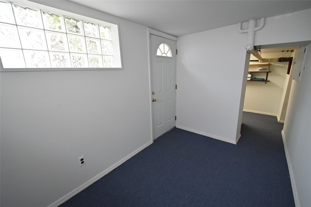 foyer featuring dark colored carpet