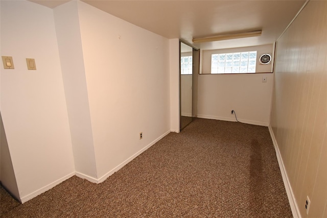 spare room featuring dark colored carpet