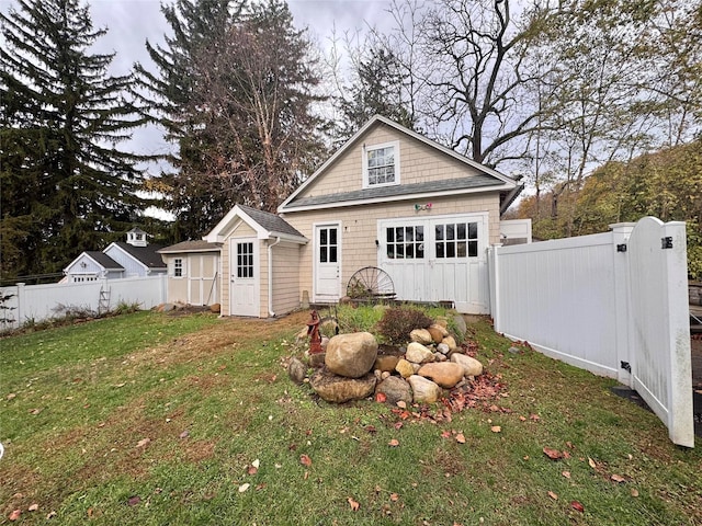 view of front of house featuring a front yard, fence, and an outdoor structure