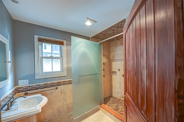 full bathroom with a stall shower, tile patterned flooring, and a sink