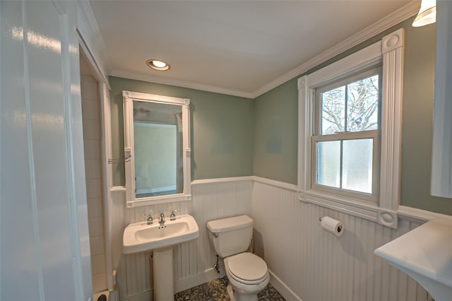 bathroom with ornamental molding, a wainscoted wall, and toilet