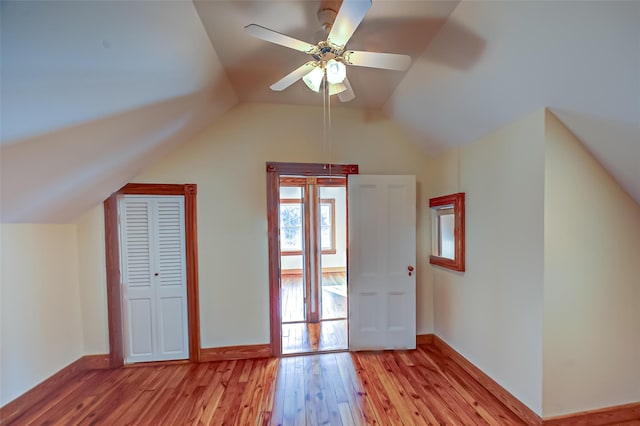 additional living space with lofted ceiling, light wood-style floors, and baseboards