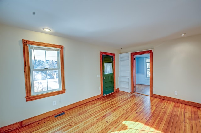 unfurnished room with recessed lighting, visible vents, light wood-style flooring, and baseboards