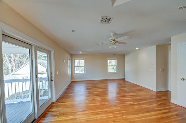 empty room featuring baseboards, a ceiling fan, visible vents, and light wood-style floors