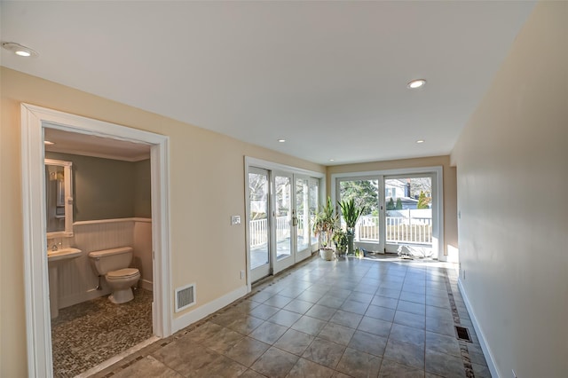 doorway to outside featuring a wainscoted wall, recessed lighting, visible vents, and french doors