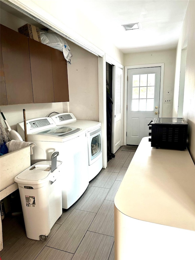 clothes washing area with separate washer and dryer and sink