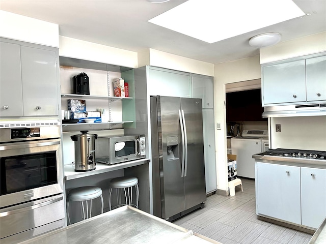 kitchen featuring washing machine and dryer and appliances with stainless steel finishes