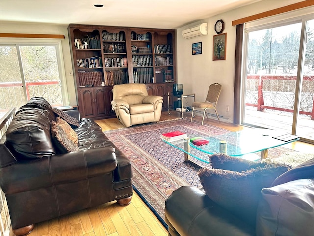 living room with plenty of natural light, light hardwood / wood-style floors, and an AC wall unit