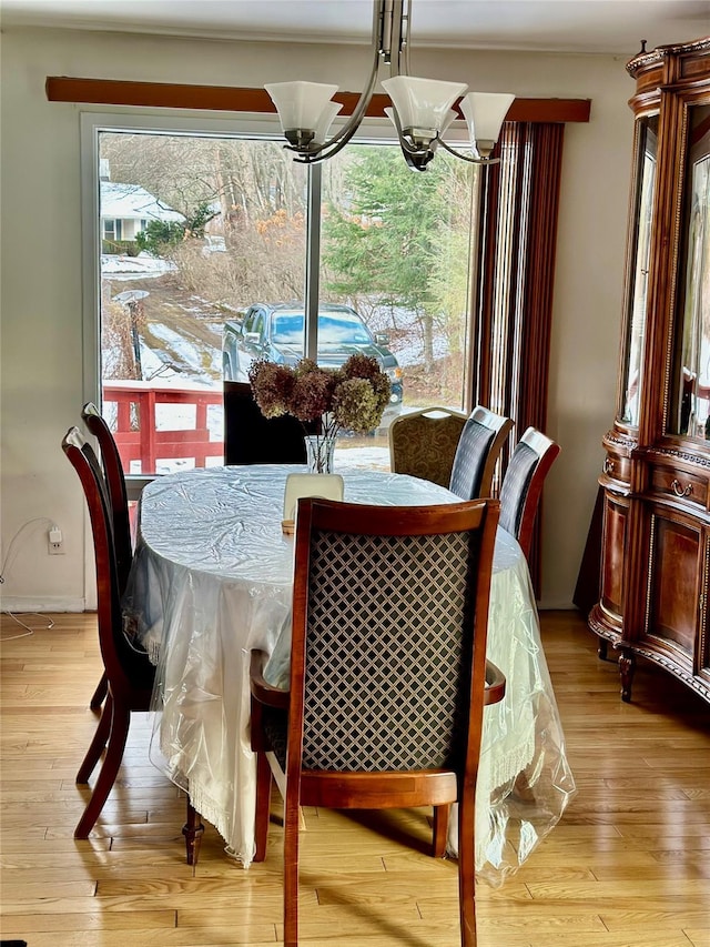 dining room with light hardwood / wood-style flooring, a wealth of natural light, and a notable chandelier