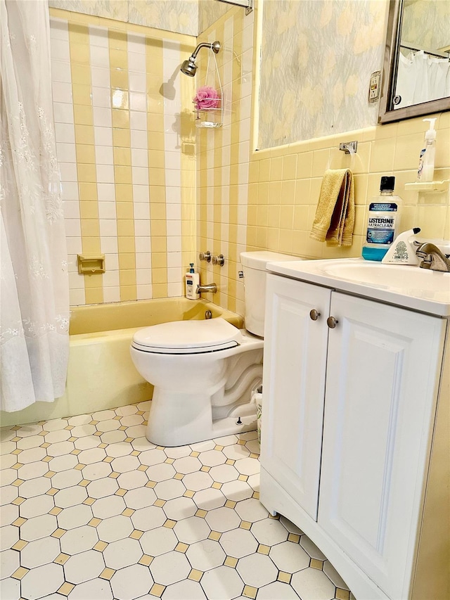 full bathroom with shower / tub combo, vanity, toilet, and tile walls