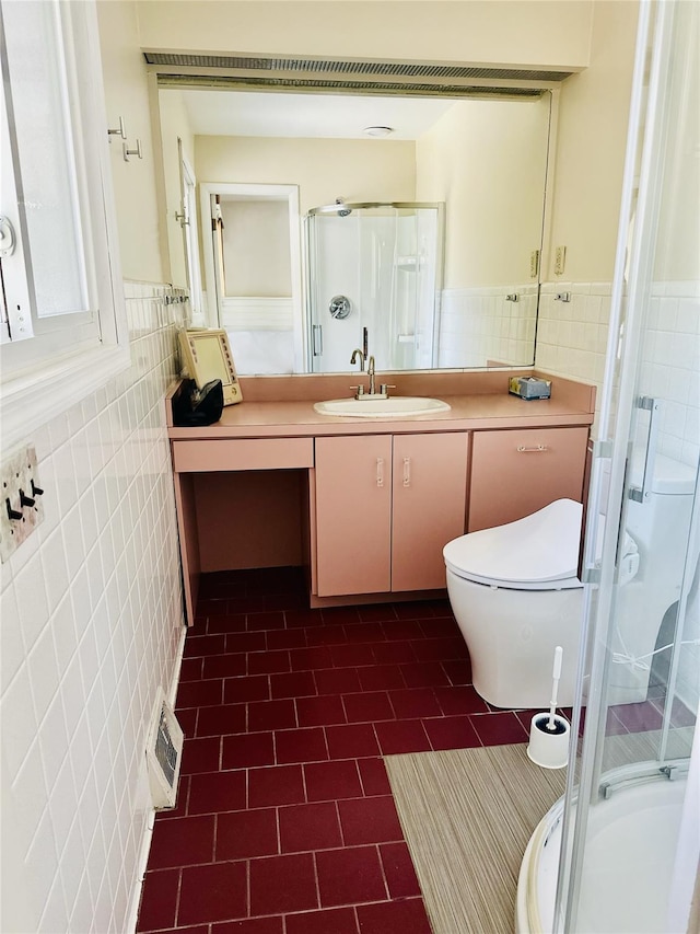 bathroom featuring vanity, toilet, a shower with door, and tile walls