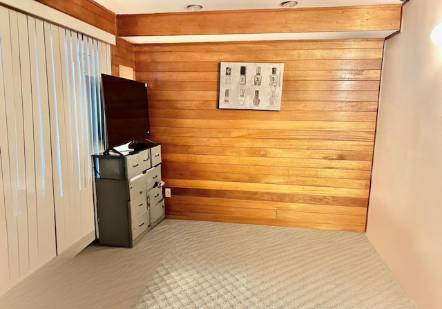 unfurnished bedroom with carpet flooring and wooden walls