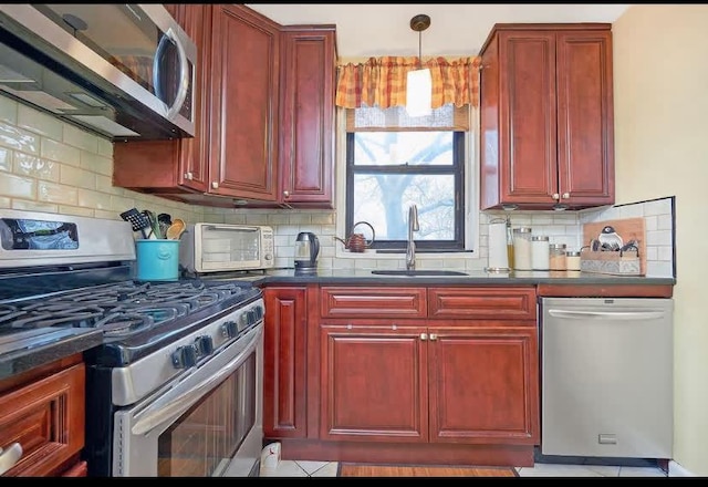 kitchen featuring hanging light fixtures, sink, appliances with stainless steel finishes, and tasteful backsplash