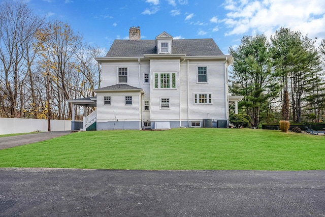 exterior space with cooling unit and a front lawn