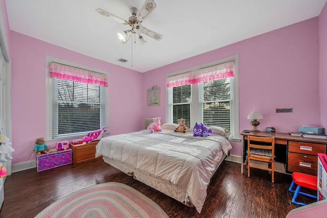 bedroom featuring multiple windows, ceiling fan, and dark hardwood / wood-style flooring