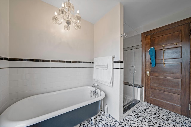 bathroom with tile patterned flooring, tile walls, plus walk in shower, and an inviting chandelier