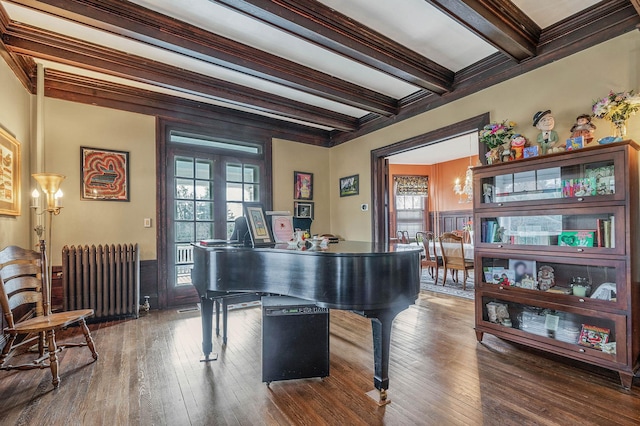 miscellaneous room with beamed ceiling, dark hardwood / wood-style floors, radiator, and ornamental molding