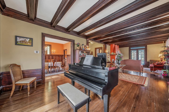 misc room featuring wood-type flooring, ornamental molding, and beam ceiling