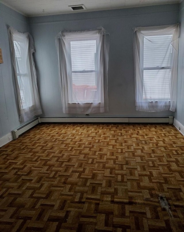 empty room featuring dark parquet floors and plenty of natural light