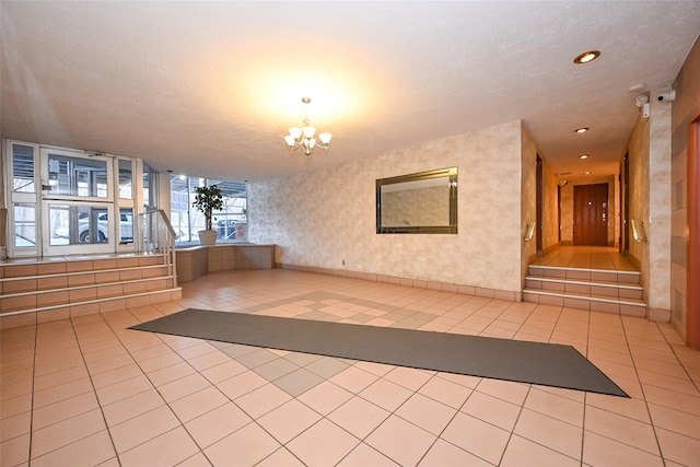 interior space with light tile patterned flooring, a textured ceiling, and an inviting chandelier