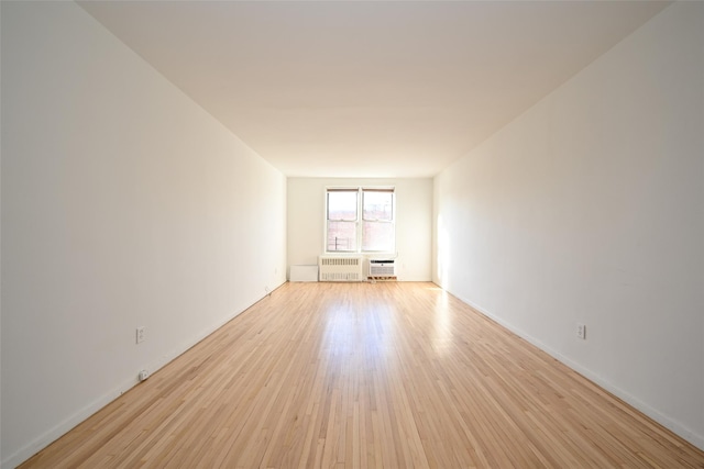 unfurnished room with light hardwood / wood-style floors and radiator