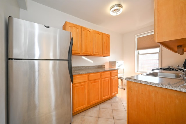 kitchen with stainless steel fridge, sink, and light tile patterned floors