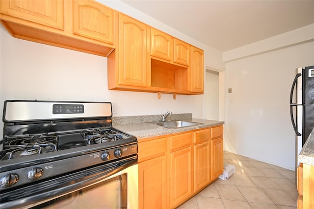 kitchen with black gas range, light tile patterned floors, and sink