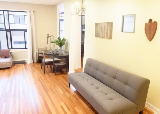 sitting room featuring hardwood / wood-style flooring, an inviting chandelier, and a healthy amount of sunlight