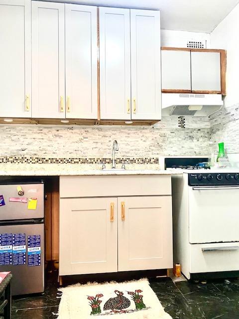 kitchen featuring white cabinetry, sink, beverage cooler, tasteful backsplash, and white stove